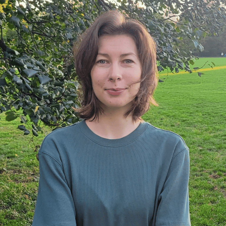 Viktoryia Kalamiyets, junior software engineer at Good Agriculture, smiling with greenery in the background